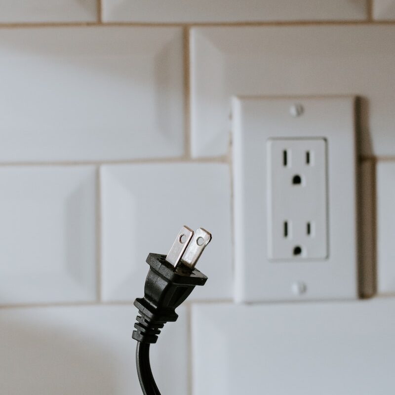 black usb cable plugged in white electric socket