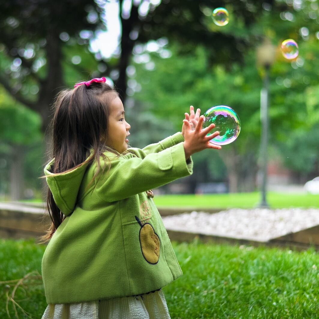 selective photo of a girl holding bubbles